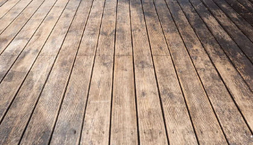 Weathered gray deck boards with dark grime before cleaning