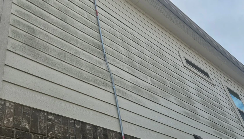 Siding streaked with dark mildew and algae before a house wash